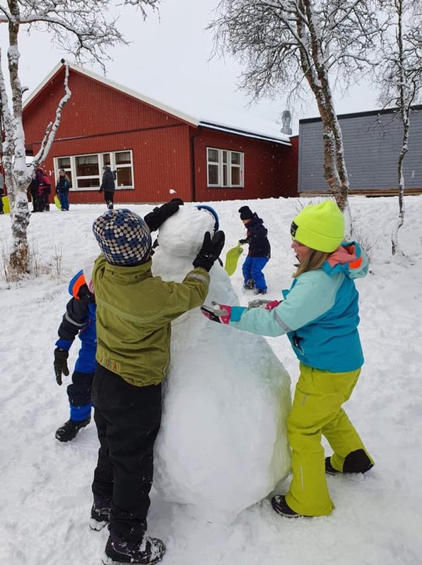 3 barn lager en snømann
