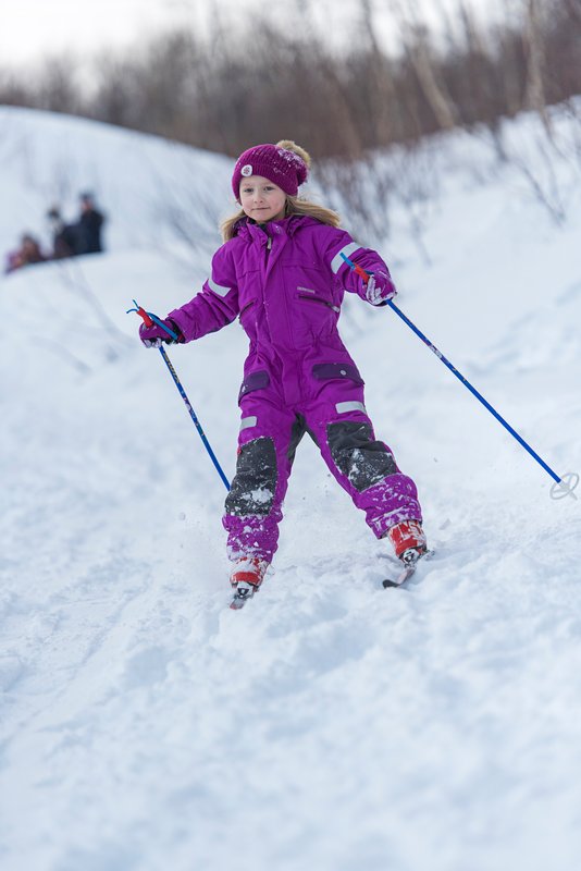 Nasjonalparklandsbyene Foto Ørjan Bertelsen. En jente i rosa dress som går på ski.