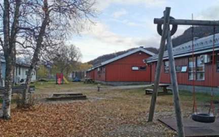 Et r&oslash;dt bygg, med deler av et dissestativ i front