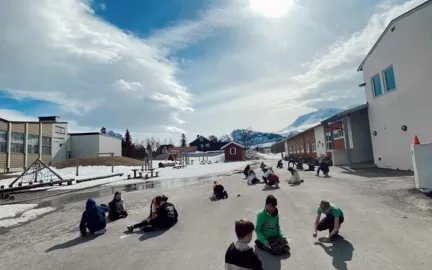 Barn som leker p&aring; asfalt, bl&aring; himmel og sol