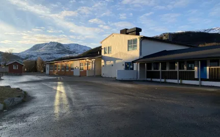 Storslett skole sett fra skoleg&aring;rden, med fjell i bakgrunnen.