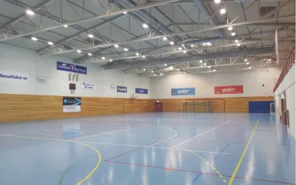 Innend&oslash;rs idrettshall med oppmerkede baner, h&aring;ndballm&aring;l og basketballkurver.