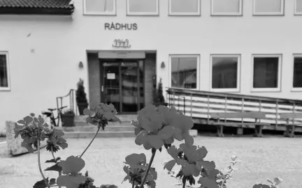 Nordreisa r&aring;dhus med blomster i forgrunnen.