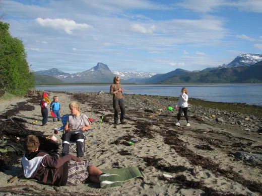 Barn og voksne i fj&aelig;ra med fjord og fjell i bakgrunnen.
