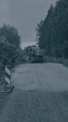 Gravemaskin i arbeid på Straumfjordnesveien i forbindelse med utbedring av veien. Gravemaskin i arbeid på Straumfjordnesveien i forbindelse med utbedring av veien. Sort hvitt bilde