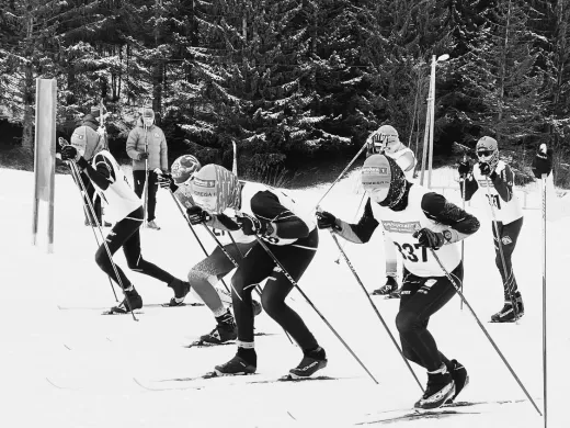 Skiglede og friluftsliv i Nordreisa Flere skiløpere går på ski sammen i et preparert skispor - sort/hvitt