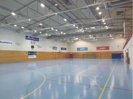 drettshallen i Nordreisa Innendørs idrettshall med oppmerkede baner, håndballmål og basketballkurver.