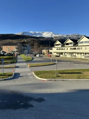 Bilde viser Storslett sentrum med bygninger, biler og vei. Bilde viser Storslett sentrum med bygninger, biler og vei