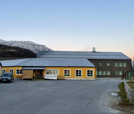 Helsestasjonen sine nye lokaler på Storslett skole Et gult bygg som henger sammen med Storslett skole