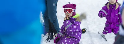 Barn leker i sn&oslash;en og spiser p&oslash;le